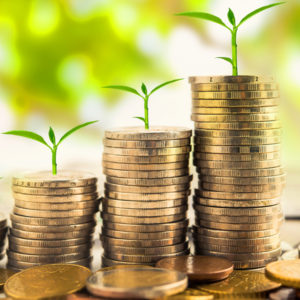 photo of three stacks of coins each with a plant growing out of the top